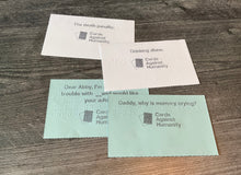 Load image into Gallery viewer, A close up on the index cards, both the blue prompt cards and the white response cards. All cards have print and braille on them