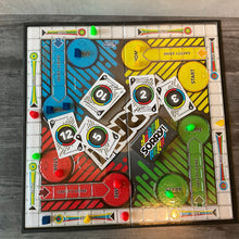 Load image into Gallery viewer, Top down view of the sorry board. The transparent thermoformed board is on the board. 3d printed replacement pieces are on the board. There are cards with transparent braille on them as well.