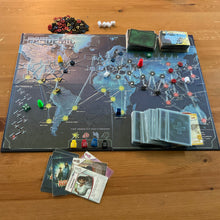 Load image into Gallery viewer, Wide shot of the board with the thermoformed overlay on it. Shows the tokens and brailled cards.