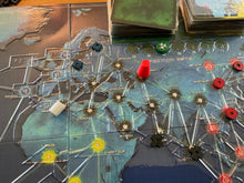 Load image into Gallery viewer, A shot of Europe with it's blue wooden pieces. A red piece is shown on the board.