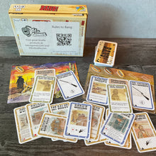 Load image into Gallery viewer, A picture of the Bang box, 2 of the player mats and various cards with braille.