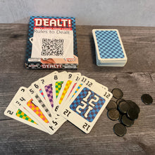 Load image into Gallery viewer, Dealt box with cards face up. The cards have transparent braille stickers on all of them from the accessibility kit. Black chips from the game are in the corner.