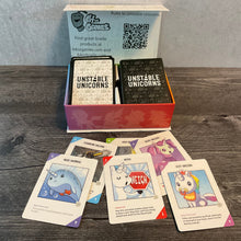 Load image into Gallery viewer, The box for unstable unicorn with 6 cards in front of it. The cards have transparent braille on them. The baby cards have transparent braille on both sides.