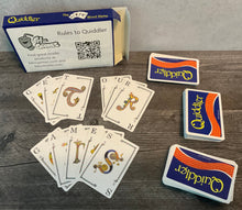 Load image into Gallery viewer, Cards laid out with transparent braille on them. The words "Get" "our" "games" are spelled out with the cards.