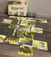 Load image into Gallery viewer, The game sort of laid out with the market in the middle and the player gardens towards the front and the back. Every card has transparent braille on it showing it's function.