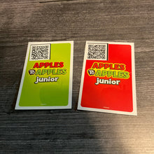 Load image into Gallery viewer, The back of the green and the red cards. A QR code sticker with the card's text is placed in the corner.