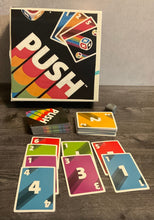 Load image into Gallery viewer, The game push. The cards with their numbers and colors are arranged in rows as one would do in the game. The 3d printed die can be seen in the background