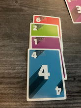 Load image into Gallery viewer, 4 cards setup in a row. They all have different numbers and colors as the rules say you must