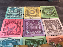 Load image into Gallery viewer, A close up of the 3x3 grid of tiles that makes up the 'board'. Each tile has a letter on it to designate it's color