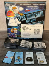 Load image into Gallery viewer, The game Star Munckin with the accessibility kit on it. The door and treasure cards all have both braille and QR codes on them