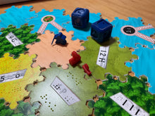 Load image into Gallery viewer, Close up on dice and robber. The robber is a meeple with a cane. The 3  for 1 port is facing the wrong direction because Richard was too hasty when setting up the photo and wasn't paying attention.