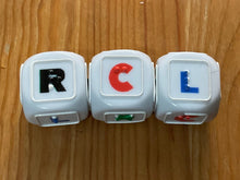 Load image into Gallery viewer, Close up on the LCR dice. Braille letter R is on r, Braille letter c is on c and surprisingly the braille letter L is on L. Not shown are the dots which have a tactile X on them(not the braille letter, just an X)