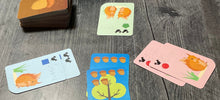 Load image into Gallery viewer, Three different players using the squirrel cards to surround a tree.