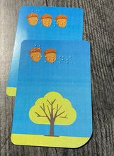 Load image into Gallery viewer, A pile of collected acorn cards in front of a player.