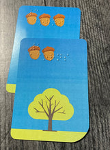 Load image into Gallery viewer, A pile of collected acorn cards in front of a player.