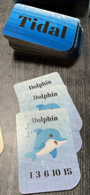Load image into Gallery viewer, The draw deck with a stack of dolphin cards in front of it.
