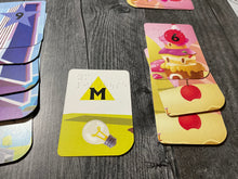 Load image into Gallery viewer, A close up of the towers that a player is currently building. The yellow cards are lighthouse themed and the red cards are candy themed