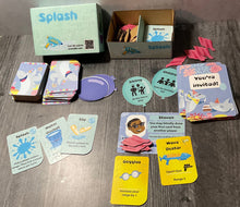 Load image into Gallery viewer, The splash box with all the components laid out. The role cards are shaped like balloons, the attendee cards are shaped like party invitations, there are laser cut towel tokens and of course the actual cards.