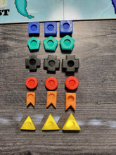 Load image into Gallery viewer, The different types of pieces. There are 3 denominations of troops, ones with no ridges, fives with 1 ridges and tens with 2 ridges.
Each color has a different shape.
All the pieces can stack on top of each other.