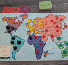 Load image into Gallery viewer, Board game map of the world with colorful markers on a wooden surface