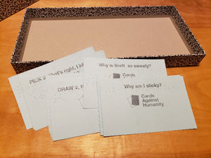 A pile of blue prompt cards is shown. Why am I sticky? and Why is Brett so sweaty? is shown