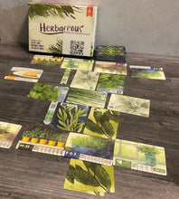 Load image into Gallery viewer, The game sort of laid out with the market in the middle and the player gardens towards the front and the back. Every card has transparent braille on it showing it's function.
