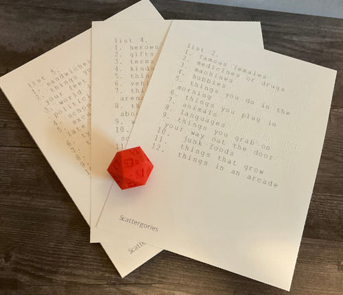 The 3d printed replacement 20 sided-die with letters on it along with the lists. All lists are in both large print and braille.